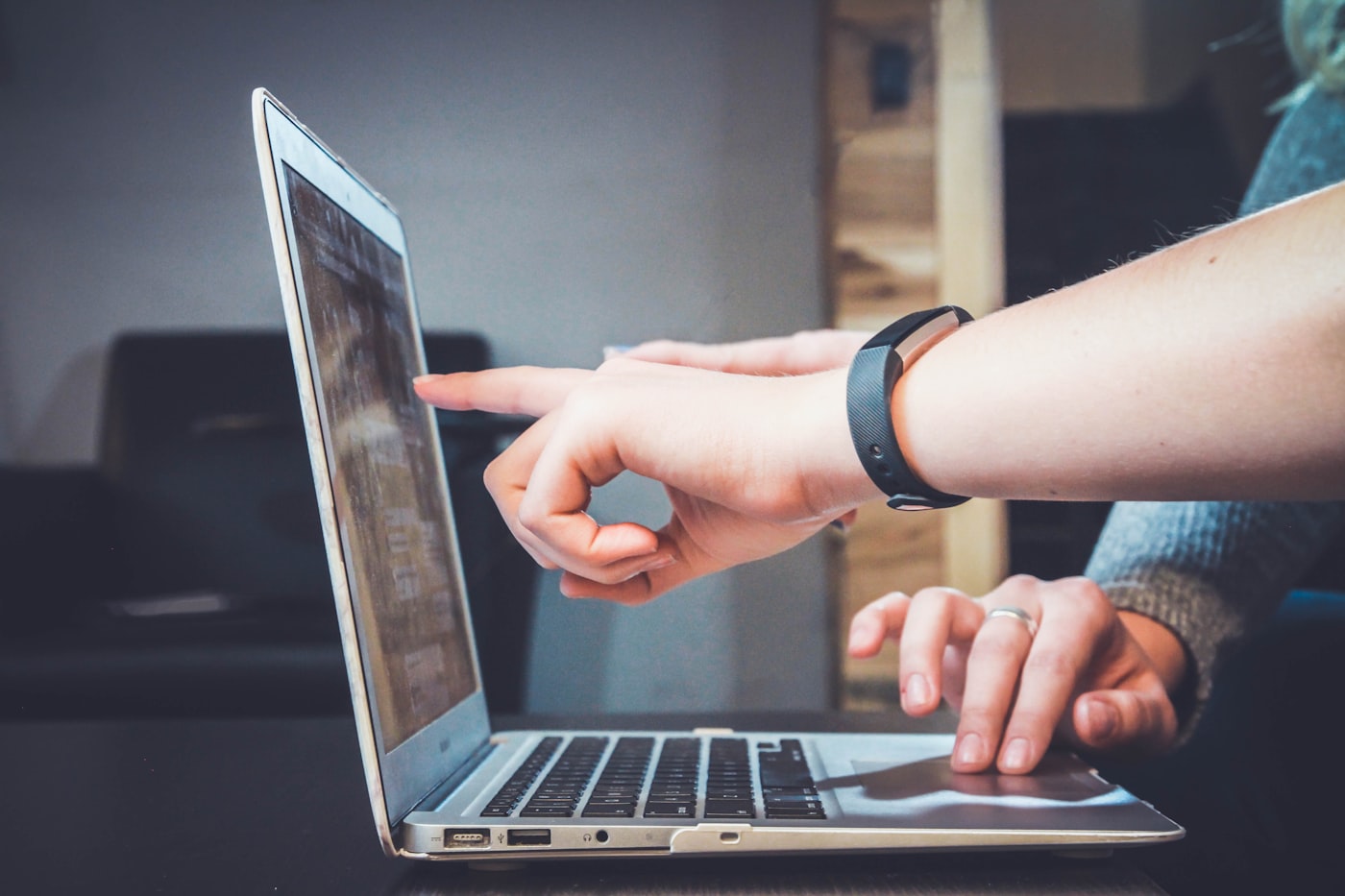 Hands collaborating on a laptop during workplace IT support