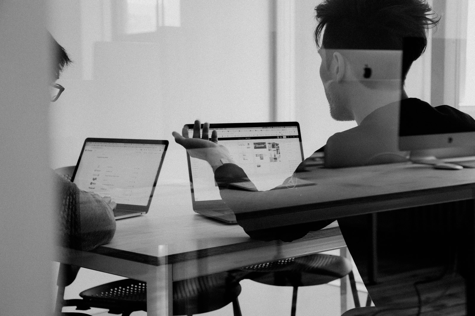 Professionals collaborating on laptops in a modern office