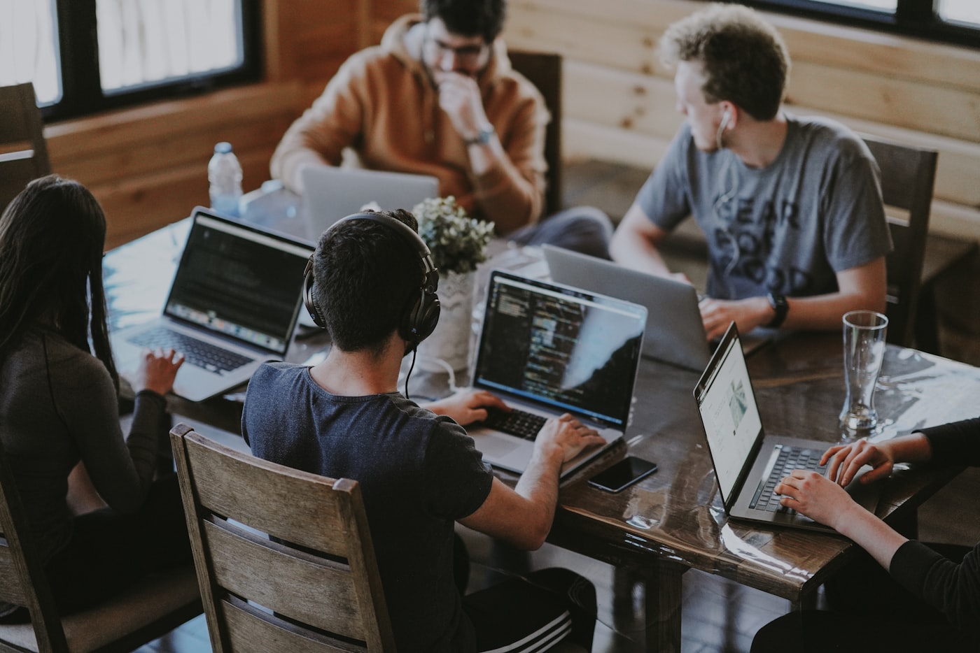 Team collaborating with laptops in a shared workspace